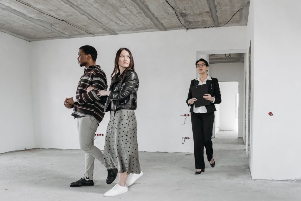 Two new homebuyers walking through the home with their real estate agent, making sure everything is as expected during the walkthrough and reinspection phases